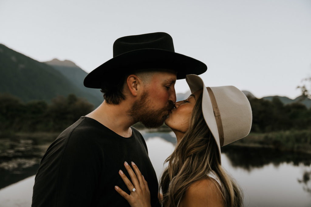 couple kissing in front of lake in pitt lake