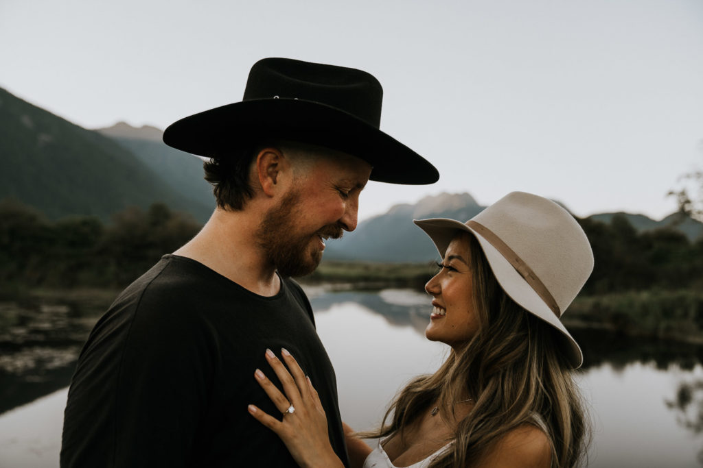couple kissing in front of lake in pitt meadows