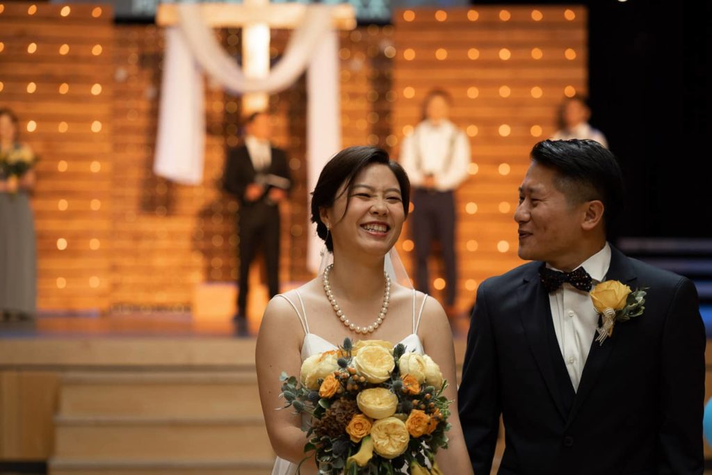 Bride and Groom laughing and smiling at Exit of the Church in Vancouver