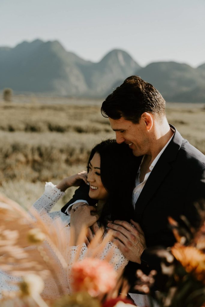 bride and groom hugs beside wedding table at pitt lake