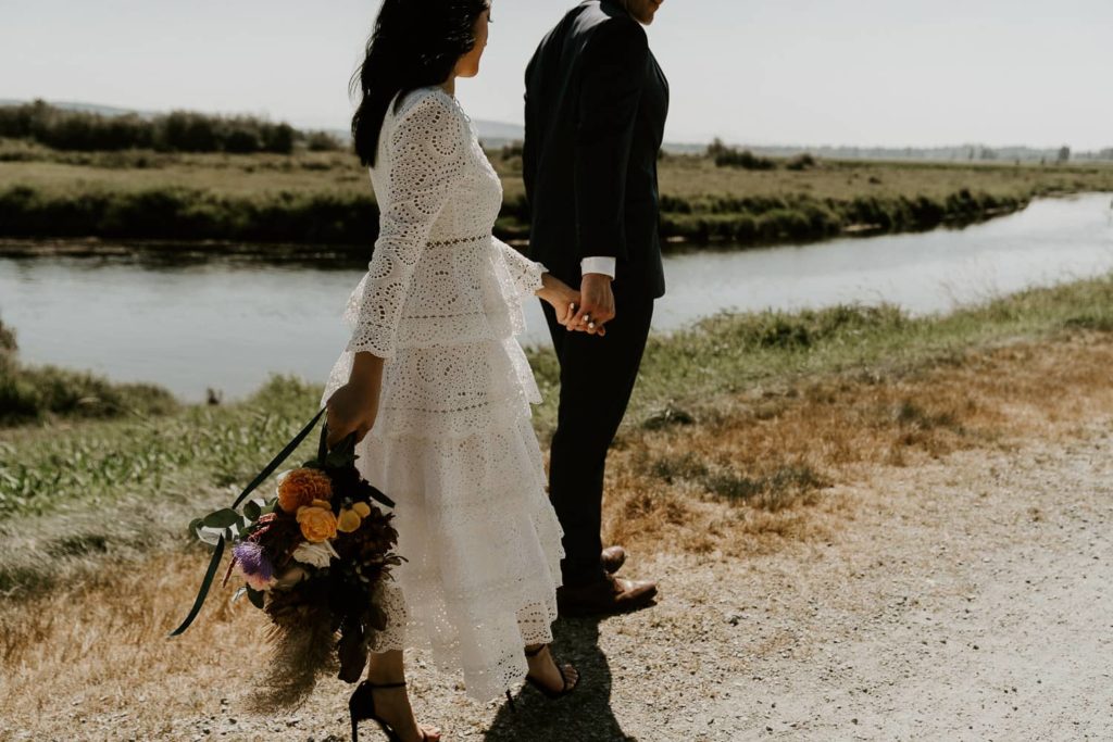 groom leading the road to the bride with wedding bouquet at pitt lake