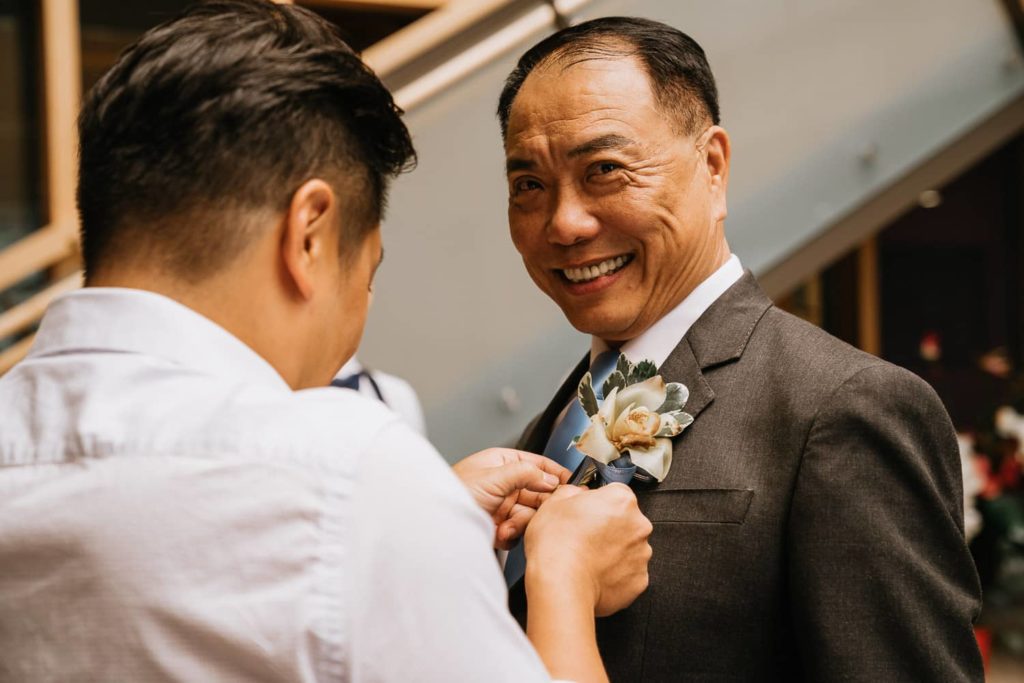 Dad getting ready boutonniere smiling